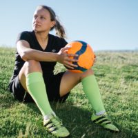 woman football player sitting on the field